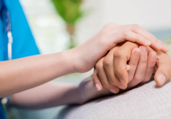 Caregiver holding a senior's hand